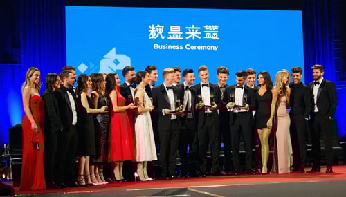 A crowded stage at a business awards ceremony